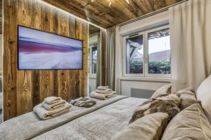 ein Schlafzimmer mit einem großen Bett und einem Flachbild-TV in der Unterkunft Le petit cœur de Megève -Mont770- in Megève