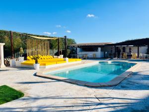 a swimming pool in a yard with yellow furniture at Villa Copacabana Súper Lujo in Palma de Mallorca
