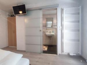 a bathroom with a sink and a toilet and a television at Gästehaus im Alten Fährhaus in Cochem