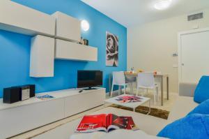 un salon avec un mur d'accent bleu dans l'établissement Domino Apt, à Sarnico