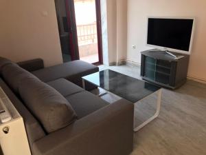 a living room with a couch and a glass coffee table at Sea Sunset Appartment in Nea Iraklia