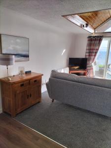 uma sala de estar com um sofá e uma mesa em Seaview cosy 2 bed home in Lamlash em Lamlash