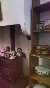 a kitchen with a stove and some plates and dishes at Sidharta Room in Villalba dels Arcs