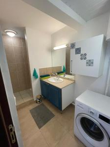 a bathroom with a sink and a washing machine at NANA COCOONING- C42- Vue Panoramique - Appartement Cosy et Lumineux- Cuisine équipée- CLIM-Terrasse in Cayenne +10 photos