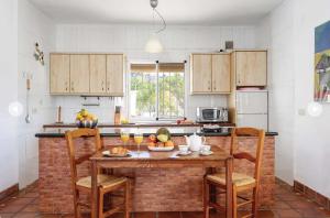 una cocina con una mesa con un bol de fruta. en LA HIGUERA en Torrox