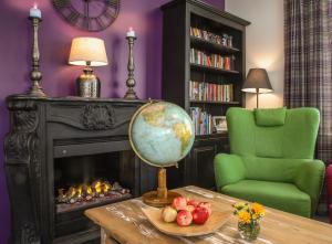 a living room with a fireplace and a globe on a table at Hotelli HiljaHelena in Kurikka