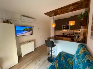 een woonkamer met een bank en een keuken bij Apartamento vistas al Mar Aire acondicionado Wifi in Empuriabrava
