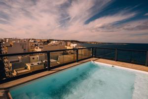 a swimming pool on the balcony of a building at Primera Hotel in St. Paul's Bay