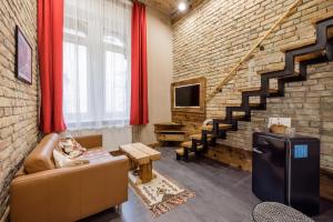 een woonkamer met een bank en een bakstenen muur bij L1 Apartments in Boedapest