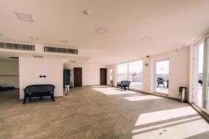 an empty room with tables and chairs and windows at Primera Hotel in St. Paul's Bay