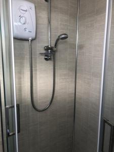 a shower with a shower head in a bathroom at Happy Chalet in Pembrokeshire