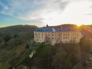 a large building on a hill with the sun in the sky at HarzRitter Domizil in Cattenstedt