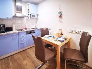 a small kitchen with a wooden table and chairs at Haus Meeresblick - Ferienwohnung Strandidyll A 1.16 (Ref. 128659 u2) in Baabe