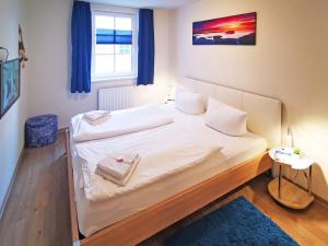 a bedroom with a large white bed with a window at Haus Meeresblick - Ferienwohnung Strandidyll A 1.16 (Ref. 128659 u2) in Baabe