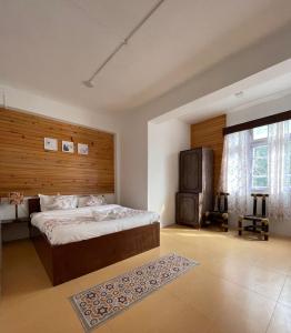 a bedroom with a large bed with a wooden headboard at Monratino Ridge View in Gangtok