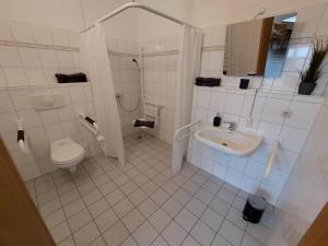 a white bathroom with a toilet and a sink at Gästehaus Heinrich Heine Schule in Bad Dürrenberg