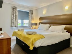 a bedroom with a large bed with a leather headboard at The Diamond Inn in Ponteland