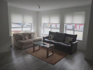 a living room with a couch and a coffee table at City, Celtic park & Emirates Stadium Apartment, for families or age over 23 in Glasgow
