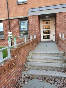 un edificio de ladrillo con escaleras que conducen a una puerta en City, Celtic park & Emirates Stadium Apartment, for families or age over 23, en Glasgow