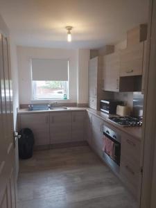 a kitchen with a sink and a stove top oven at City, Celtic park & Emirates Stadium Apartment, for families or age over 23 in Glasgow