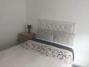 1 dormitorio con 1 cama con edredón blanco en City, Celtic park & Emirates Stadium Apartment, for families or age over 23 en Glasgow