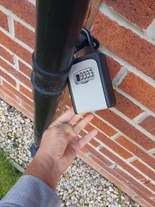 a person holding a digital meter next to a brick wall at City, Celtic park & Emirates Stadium Apartment, for families or age over 23 in Glasgow