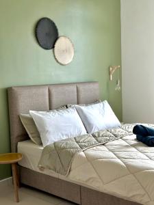 1 cama con almohadas blancas en Wabi-Sabi Guesthouse At Ipoh Town 侘寂风民宿 en Ipoh