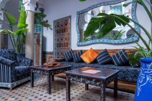 een woonkamer met een bank en tafels bij Riad Zinoun & Spa 9 Rooms in Marrakesh