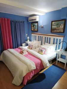 two beds in a bedroom with blue walls at Forte Apartment in Albufeira
