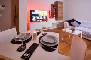 uma sala de estar com uma mesa com pratos e copos de vinho em Center Aviano Comfort Suite FREE PARKING WIFI em Aviano