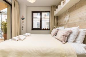 a bedroom with a large white bed with towels on it at Luxury Central Apartment in Plovdiv