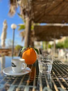 een kop koffie en een sinaasappel op een tafel bij Sergio Apartment in Durrës