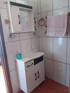 a white bathroom with a sink and a mirror at Apart Hotel Esperança in Ametista do Sul