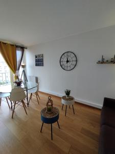uma sala de estar com uma mesa e um relógio na parede em Ô Pied Marin em Le Tréport