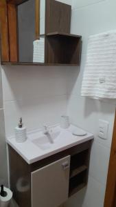 a bathroom with a sink and a mirror at Flat Embaú in Palhoça