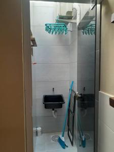 a bathroom with a sink and a toilet and mop at Flat Embaú in Palhoça +5 photos