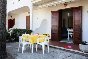 ein gelber Tisch und Stühle vor einem Haus in der Unterkunft Residence El Patio in Rosolina Mare