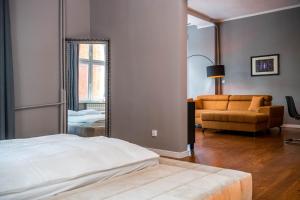 - une chambre avec un lit, un miroir et un canapé dans l'établissement AH Apartamenty - Park, à Ełk