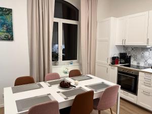 a white kitchen with a white table and chairs at Aviatik apartmány-Černý Důl in Černý Dŭl
