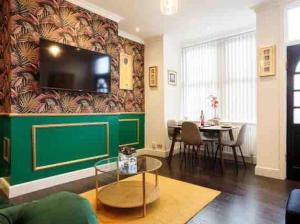sala de estar con una pared verde y TV en Luxury 2 Bedroom Home en Leeds