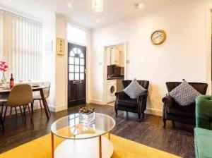 a living room with a table and a dining room at Luxury 2 Bedroom Home in Leeds