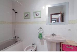 e bagno con lavandino, specchio e vasca. di Alojamientos Marte apartamentos a Torrelavega