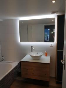 y baño con lavabo, espejo y bañera. en 47 qm- Suite mit grosszügiger Terrasse, en Oberterzen
