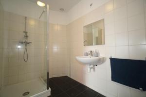 a white bathroom with a sink and a shower at Long Term Rental - Beautiful Apt City center Free Parking in Rotterdam +31 photos