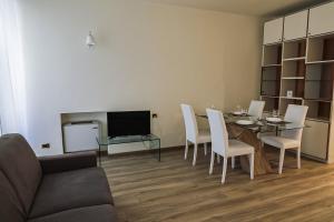 - un salon avec une table, des chaises et une télévision dans l'établissement Juliet Deluxe Apartment, à Vérone