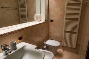 un bagno con lavandino, WC e specchio di Juliet Deluxe Apartment a Verona Altre 5 foto