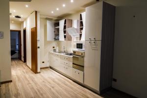 La cuisine est équipée de placards blancs et d'un four avec plaques de cuisson. dans l'établissement Juliet Deluxe Apartment, à Vérone