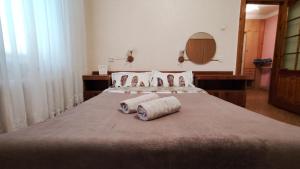 ein großes Bett mit zwei gewalzten Handtüchern darauf in der Unterkunft Vasylia Stusa 3 CityRooms in Bila Zerkwa