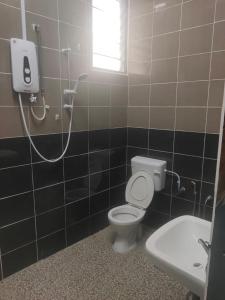 La salle de bains est pourvue de toilettes et d'un lavabo. dans l'établissement Distance 1km from beach and town, à Port Dickson