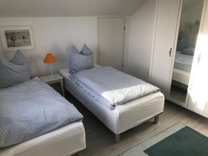- une chambre avec 2 lits et un miroir dans l'établissement Ferienwohnung Sonnendeck, à Eckernförde
